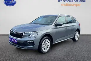 Vue 3/4 avant droit d'un Skoda Kamiq gris avec calandre chromée et jantes alu blanches.
