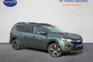 Vue 3/4 avant droit du Dacia Jogger 2025 vert cèdre métallisé avec jantes noires et toit noir contrasté.