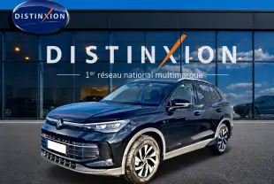 Volkswagen Tiguan noir 2025 en 3/4 avant droit, avec jantes spécifiques et calandre moderne devant showroom Distinxion.