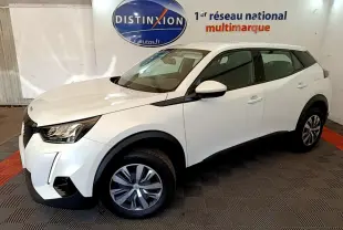Peugeot 2008 blanc vue 3/4 avant droit, avec phares LED et jantes alliage, sur sol damier intérieur showroom.