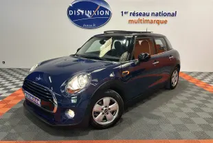 Vue 3/4 avant droite d'une MINI 5 portes Cooper D bleu avec toit ouvrant dans un showroom lumineux.
