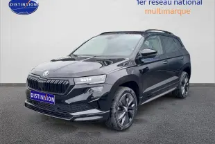 Vue 3/4 avant droite d'un Skoda Karoq noir 2025 avec jantes alu et barres de toit visibles.