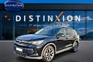 Volkswagen Tiguan noir 2025 en 3/4 avant droit, avec jantes spécifiques et calandre moderne devant showroom Distinxion.