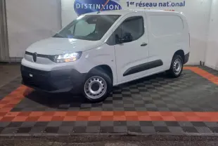 Vue 3/4 avant gauche d’un utilitaire Citroën Berlingo blanc avec phares allumés et jantes acier.