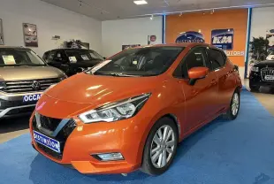 Vue 3/4 avant d'une Nissan Micra N-Connecta orange métal exposée en showroom avec éclairage intérieur.