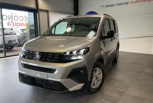 Peugeot Rifter gris Artense vu en 3/4 avant droit dans un showroom, avec calandre noire et jantes tôles 16 pouces.