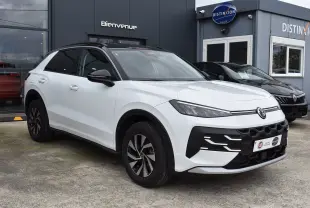 Volkswagen T-Roc blanc vue 3/4 avant droit avec toit noir et jantes alliage bicolores.
