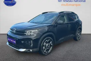 Citroën C5 Aircross noir vue 3/4 avant droit, avec jantes alu et barres de toit visibles.