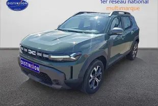 Vue 3/4 avant droit du Dacia Duster 2025 vert kaki avec jantes alu et barres de toit visibles.