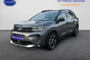 Citroën C5 Aircross gris métallisé vue 3/4 avant droit avec jantes alu et barres de toit noires.
