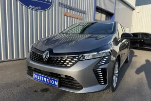 Renault Clio V gris schiste métal vue 3/4 avant droit, avec calandre noire et feux LED distinctifs allumés.