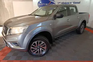 Nissan Navara Double-Cab gris clair vu en 3/4 avant droit, avec jantes alliage et benne pick-up visible.