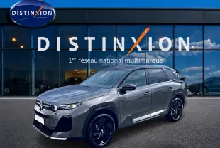 Vue 3/4 avant droit du Citroën C5 Aircross gris platinium avec jantes alliage noires devant un showroom Distinxion.