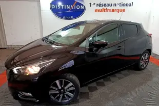 Nissan Micra IG-T 90 N-Connecta noire vue 3/4 avant droit, phares allumés, jantes alliage et rétroviseurs noirs.