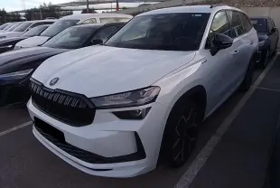 Vue 3/4 avant droite d’un Skoda Kodiaq blanc Glacier avec calandre noire et jantes anthracite 20 pouces.