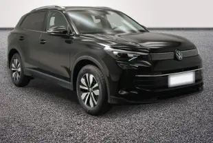 Volkswagen Tiguan noir vu 3/4 avant droit, avec jantes distinctives et calandre épurée.