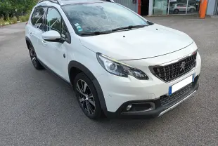 Peugeot 2008 blanc vue 3/4 avant droit, avec jantes alliage noires et toit ouvrant visible.