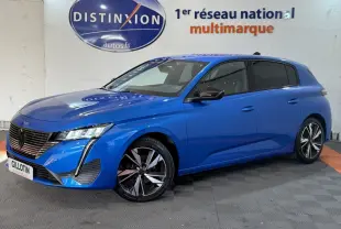 Peugeot 308 bleu en 3/4 avant droit, avec phares LED et jantes alliage distinctives, stationnée en intérieur.