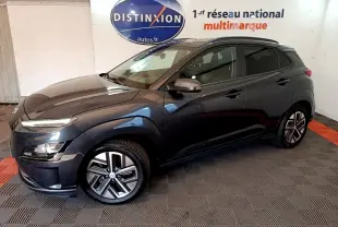 Hyundai Kona électrique 2021 gris foncé en 3/4 avant droit, avec jantes spécifiques et rails de toit noirs visibles.