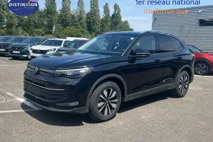 Volkswagen Tiguan noir Grenadilla 3/4 avant droit, roues alliage et calandre épurée sous un ciel bleu.