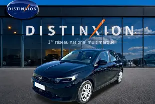 Opel Corsa noire vue en 3/4 avant droit, avec jantes argentées, devant une vitrine Distinxion.