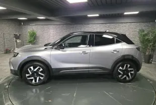 Opel Mokka-e 2025 gris avec toit noir, vue de profil côté gauche, jantes alliage diamantées 17 pouces.