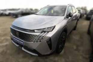 Vue 3/4 avant droite d'un Peugeot 5008 gris Artense avec calandre distinctive et phares LED fins.