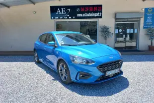 Ford Focus 2019 bleu en 3/4 avant droit, version ST-Line avec calandre noire et jantes alliage visibles.