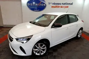 Vue 3/4 avant d'une Opel Corsa blanche 2023 avec jantes alliage et rétroviseurs noirs en intérieur showroom.
