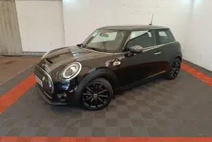 MINI Cooper SE noire vue en 3/4 avant droit, avec jantes noires et toit assorti dans un espace fermé.
