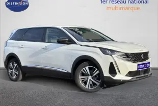 Peugeot 5008 blanc nacré vue 3/4 avant droit avec calandre noire et jantes alu bicolores.