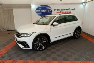 Volkswagen Tiguan 1.4 eHybrid blanc en 3/4 avant droit, avec jantes noires et détails R-Line visibles.