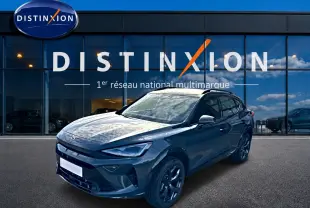 Vue 3/4 avant d'un CUPRA Formentor 1.5 etsi hybrid bleu fjord avec jantes noires devant un showroom Distinxion.