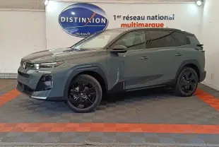 Vue de profil droit d'une Citroën C5 hybride 145ch auto MAX vert avec jantes noires et toit noir en intérieur showroom.