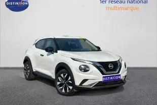 Nissan Juke blanc nacré vue 3/4 avant droit, avec calandre noire et jantes bicolores distinctives.