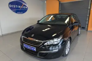 Peugeot 308 noire vue en 3/4 avant droit dans un showroom avec logo Distinxion en arrière-plan.