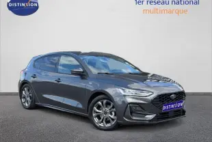 Ford Focus 2025 gris lunaire métallisé vue 3/4 avant avec calandre noire et jantes alu brillantes.