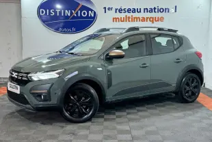 Vue 3/4 avant droite d'une Dacia Sandero Extreme+ TCe 110 2024 verte avec jantes noires et barres de toit assorties.