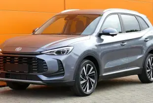 MG ZS Hybrid+ 2025 gris, vue 3/4 avant droit, avec calandre noire large et jantes alliage bicolores.