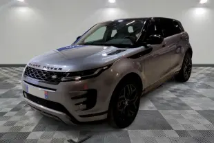Vue 3/4 avant d'un Range Rover Evoque 200D SE R-Dynamic gris Eiger avec jantes noires, devant un showroom multimarque.