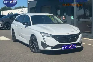 Peugeot 308 SW blanc Okénite vue 3/4 avant droit, avec jantes alliage et calandre noire distinctive.