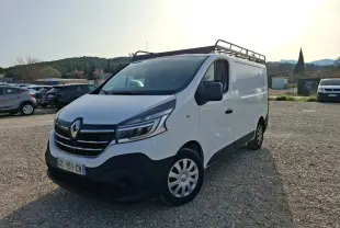 Renault Trafic Fourgon blanc vu en 3/4 avant droit avec galerie de toit et calandre noire distinctive.