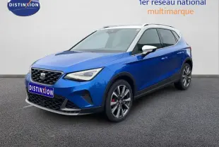 SEAT Arona 2025 bleu saphir métal avec toit blanc, vue 3/4 avant droit, jantes alliage et calandre distinctive.