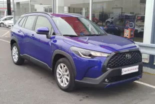 Toyota Corolla Cross bleu cosmique vue en 3/4 avant droit, avec calandre noire et jantes alliage argentées.