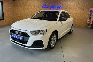 Audi A1 blanche vue en 3/4 avant droit, avec calandre noire et jantes alu 17 pouces dans un garage.