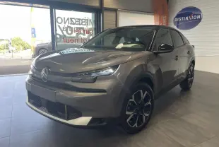 Citroën C4 gris métallisé vue 3/4 avant droit en intérieur avec toit bi-ton noir et jantes 18 pouces.