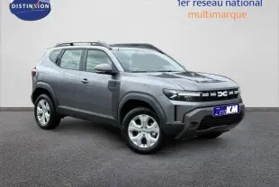 Vue 3/4 avant d'un Dacia Duster 1.2 hybrid-G gris schiste avec jantes alu et barres de toit visibles.