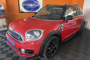 MINI Countryman Cooper SSE hybride rouge avec toit noir, vue 3/4 avant droit, jantes noires et barres de toit visibles.