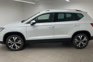 Vue de profil côté gauche d'un SEAT Ateca blanc Nevada avec jantes alliage 18 pouces et toit ouvrant.