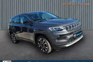 Jeep Compass gris 3/4 avant droit avec jantes alliage 18 pouces, calandre distinctive et phares LED visibles.